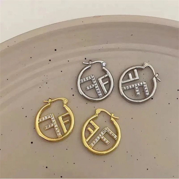 Серьги-кольца в золотистой оправе с символом CJR56666