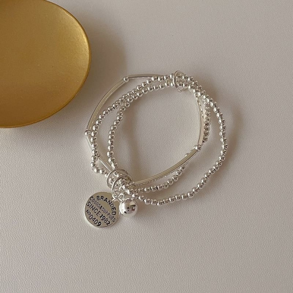 Многослойный браслет из серебристых бусин с жетоном CJE02756