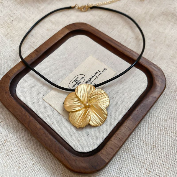 Лаконичное колье на шнурке с подвеской-цветком в золотистой оправе CJP44865