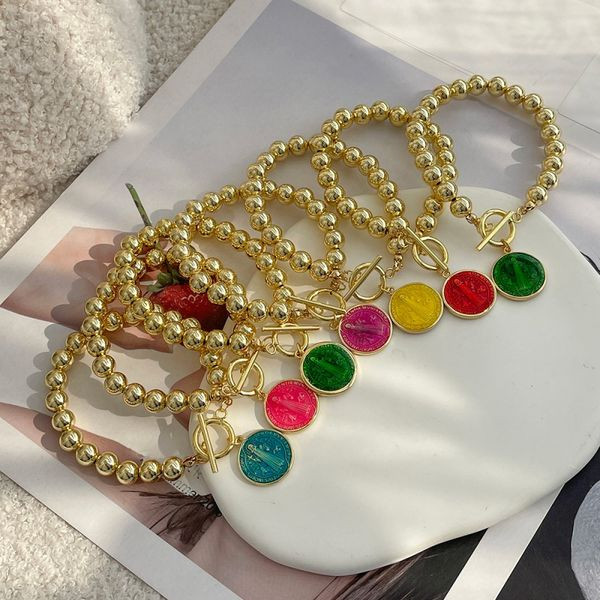Браслет из золотистых бусин с цветным медальоном CJL46654