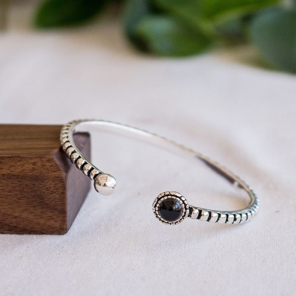 Браслет жесткий разомкнутый с темным декоративным камнем A50050MSK