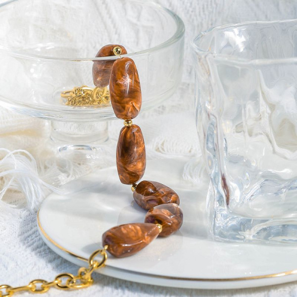 Колье из крупных нежно-розовых камней в золотистой оправе CJP93451