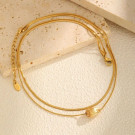 Золотистый жесткий браслет с шариками CJM63185