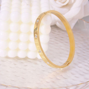 Браслет жесткий золотистый с символичной гравировкой CJL17748